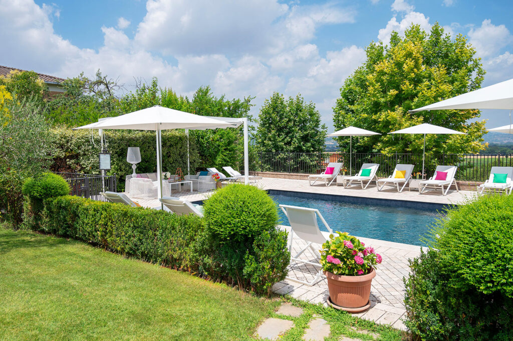 Piscina all’aperto con solarium e vista sulle colline umbre presso Boutique Hotel Al Grappolo d’Oro